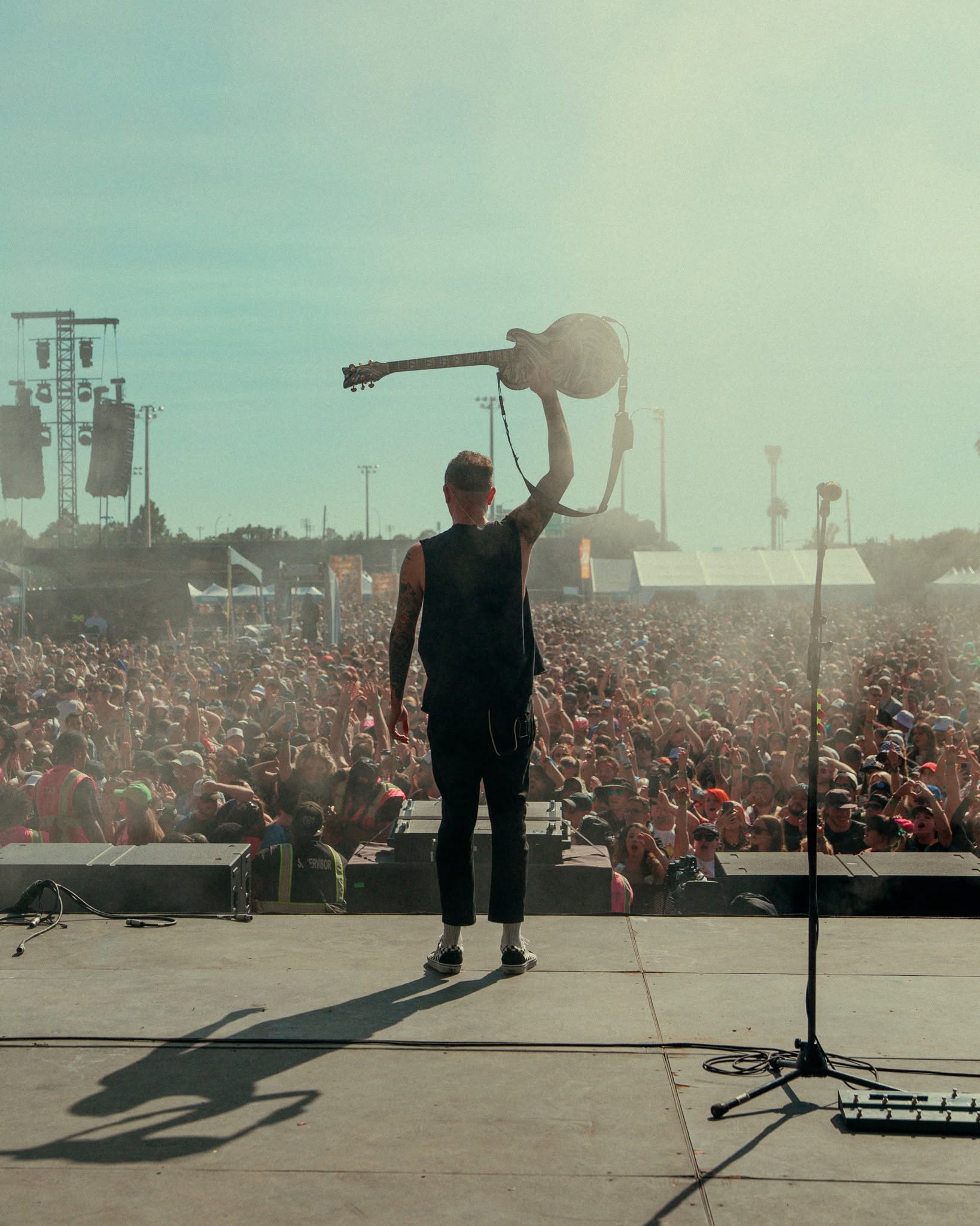 A Warped Tour main stage set in front of a packed daytime festival crowd